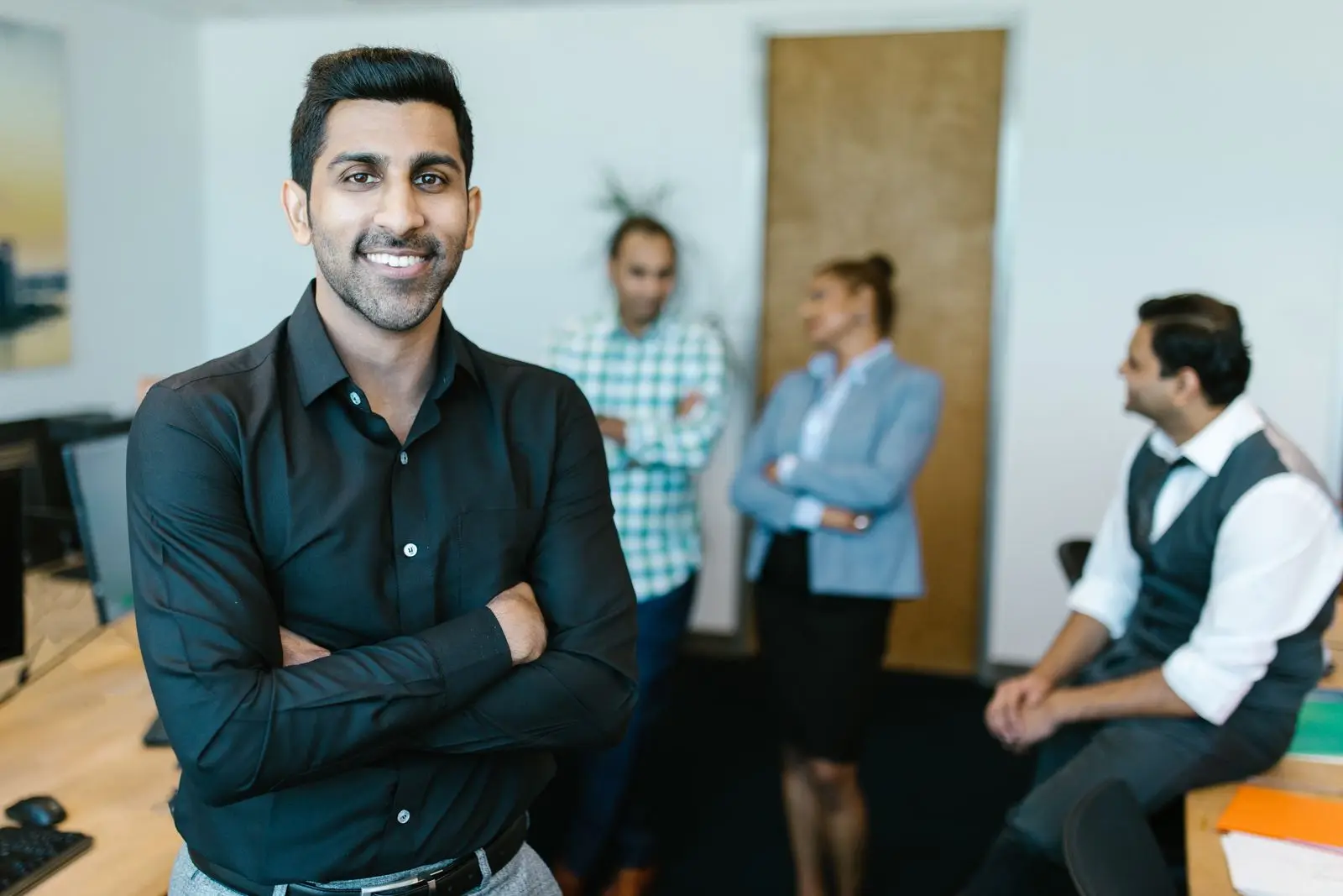 A confident business leader with his team in the background
