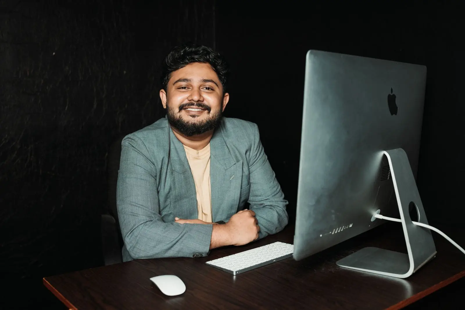 A smiling entrepreneur at the desk of his own business