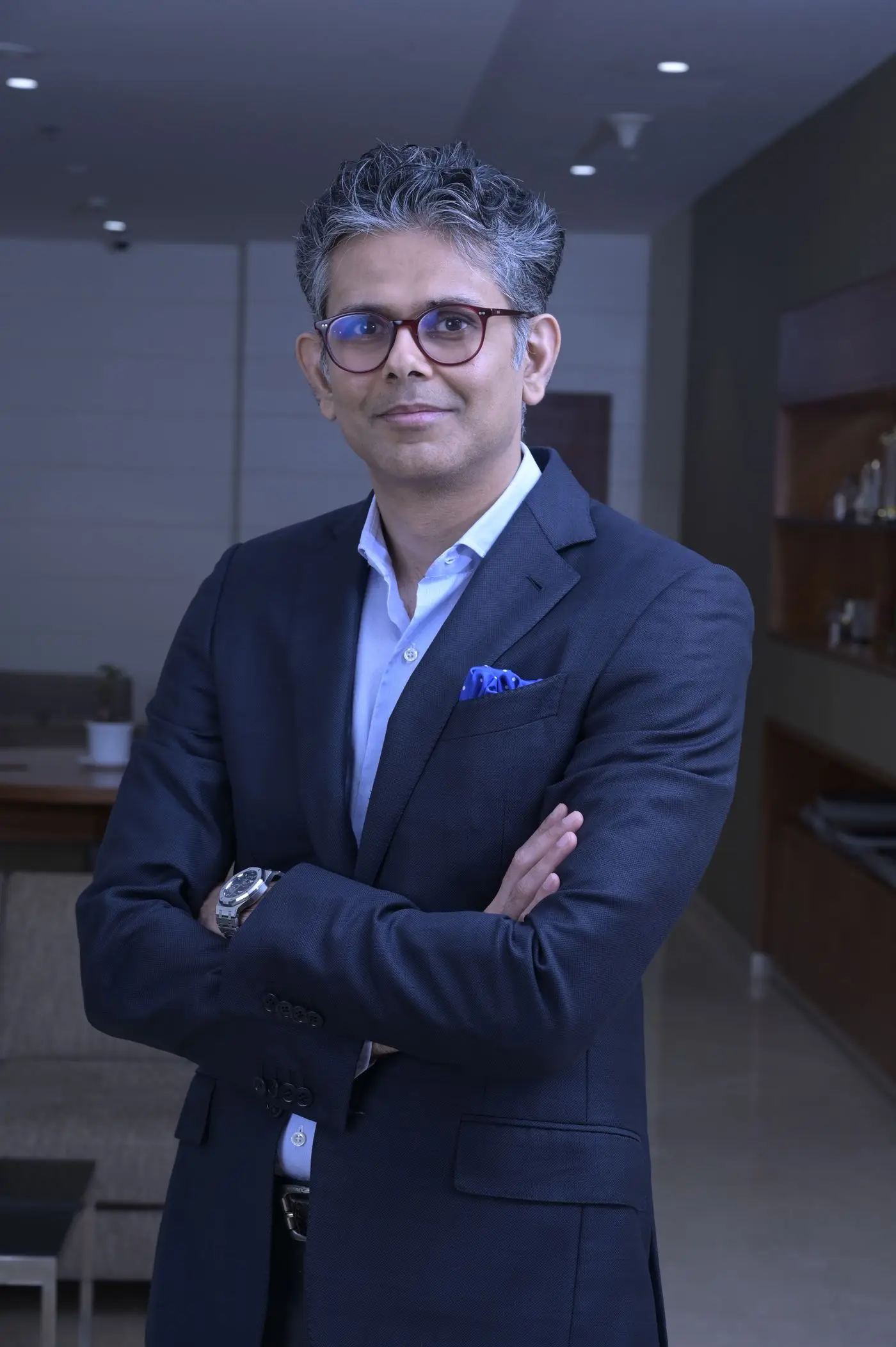 A senior business leader standing confidently in his office